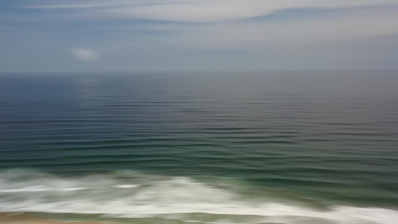 Open ocean with low surf near the bottom of the frame