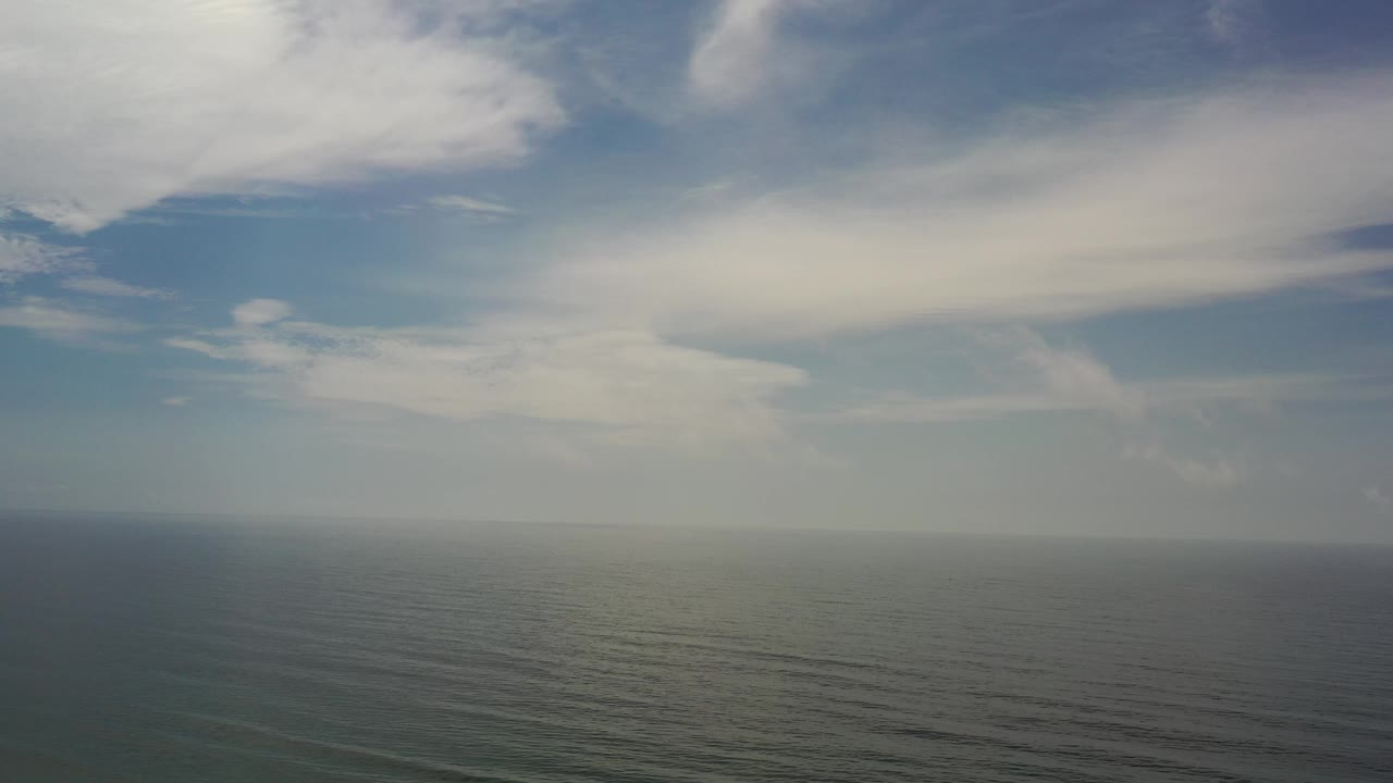 Wide ocean horizon under large white clouds