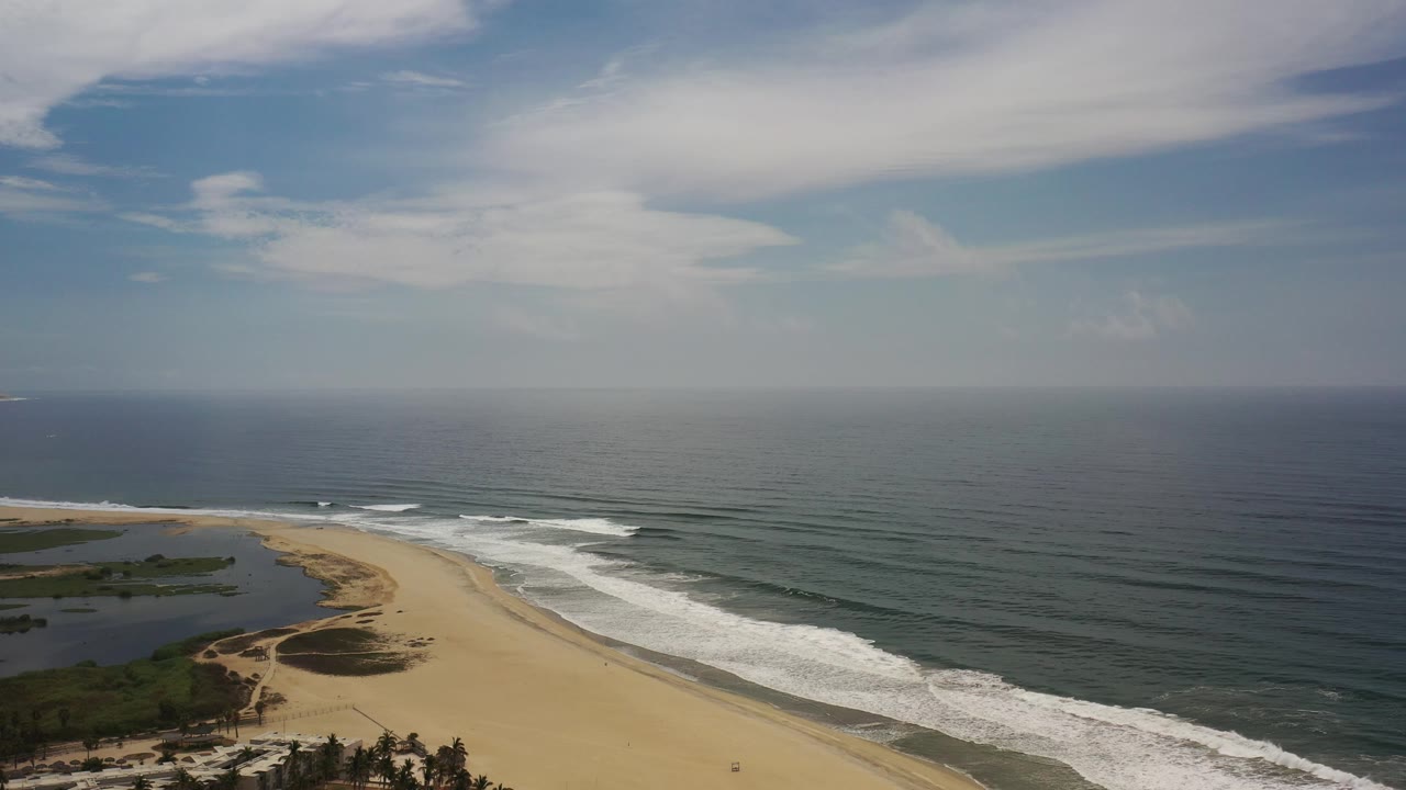 Remote sandy shoreline with ocean surf from above