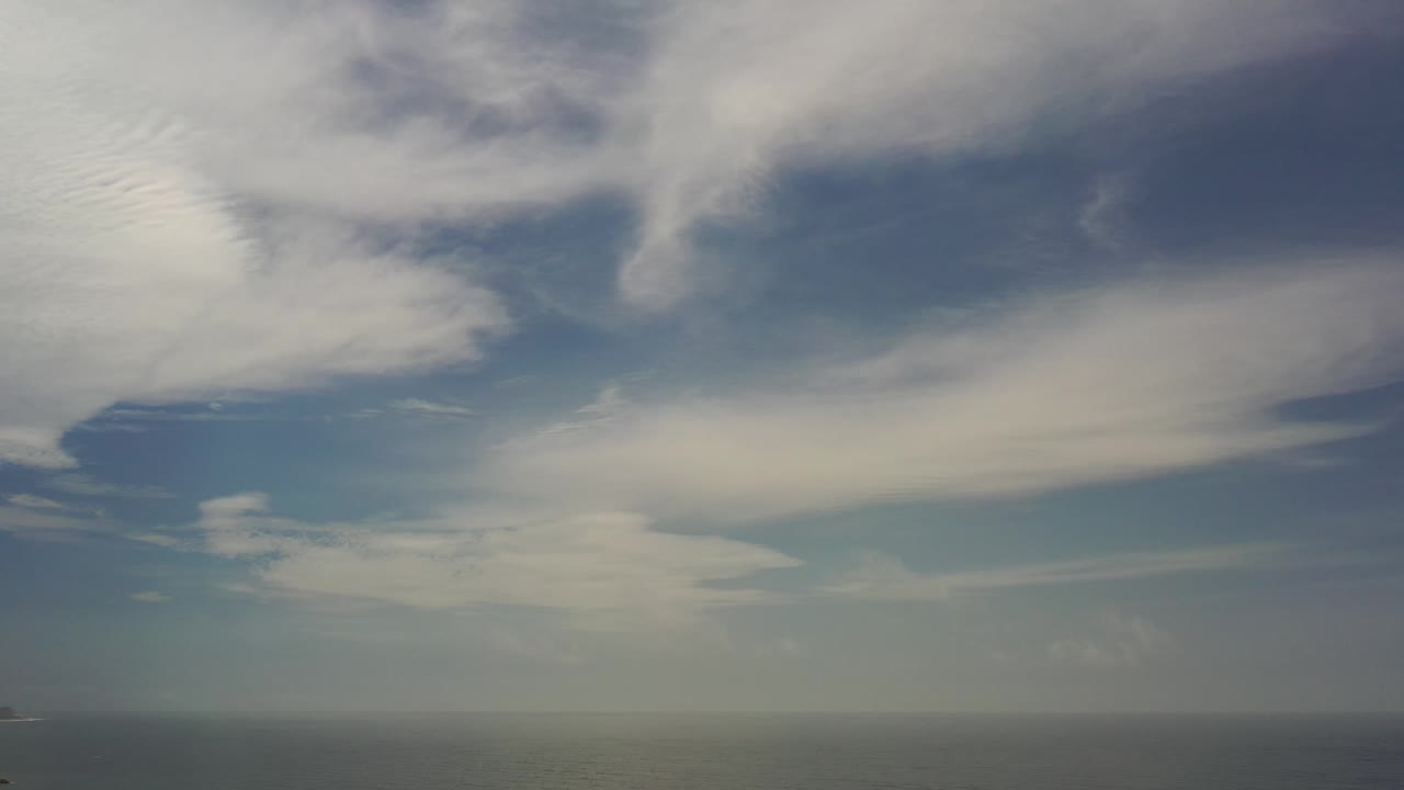 Wide blue sky with pale cloud sheets and a low distant horizon.