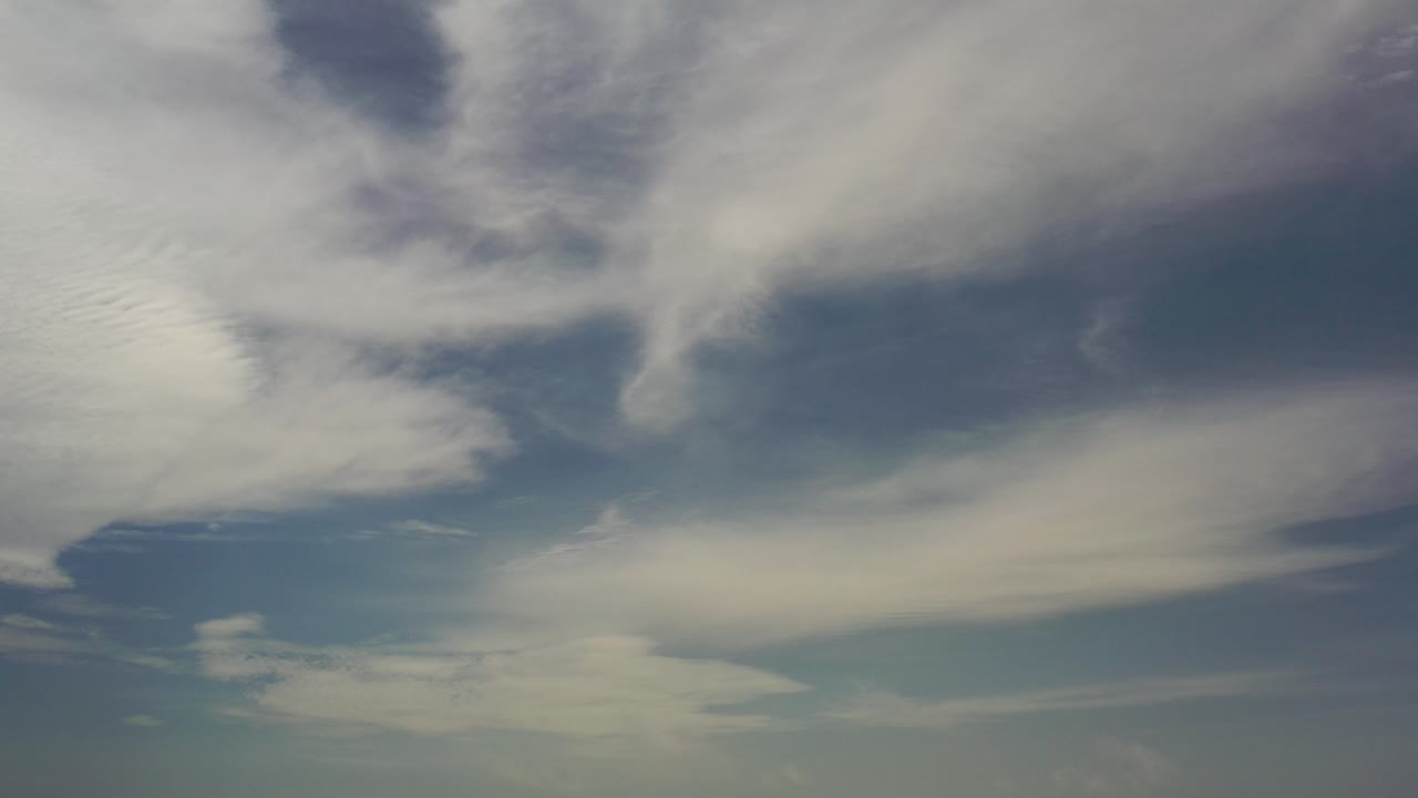 White and gray cloud bands spread across a deep blue Los Cabos sky at the start of the clip, with no visible people.