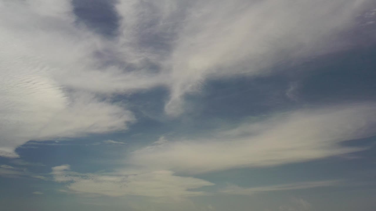 Bright cloud streaks and blue sky gaps.
