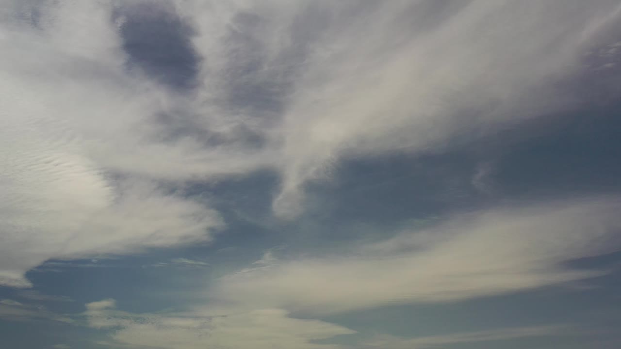 Cloud banks spread diagonally through a blue sky.