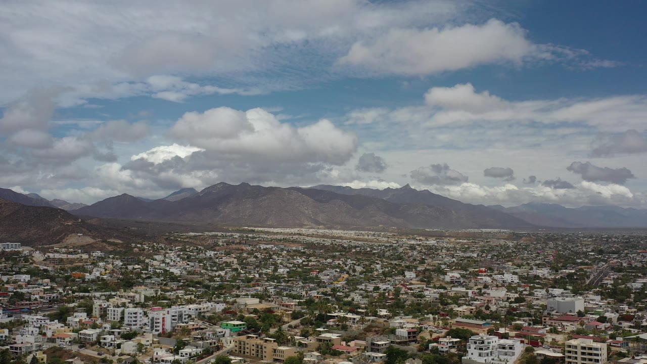 Urban aerial landscape with mountains and bright clouds.
