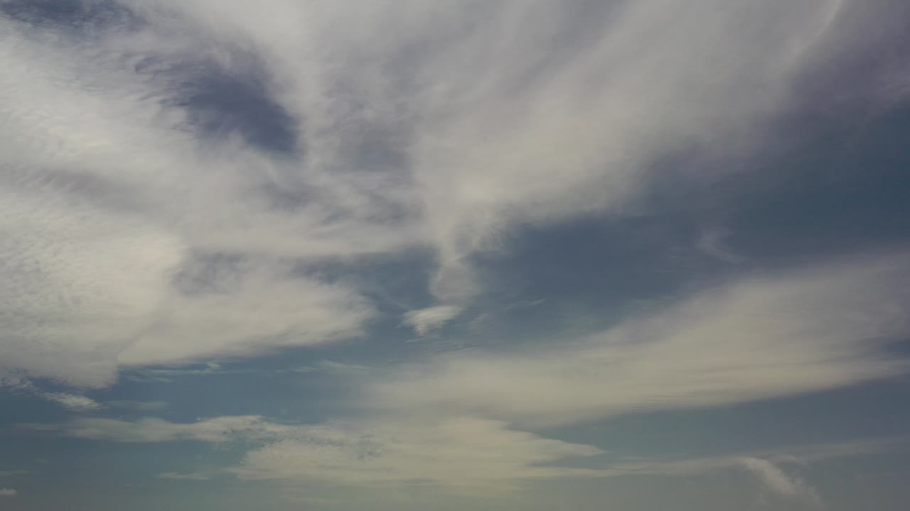 Opening frame of thin white and gray clouds spread across a light blue Los Cabos sky, with no visible people.