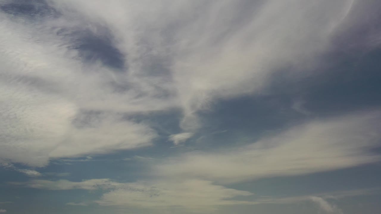 Soft white clouds with darker gray shading in blue sky.