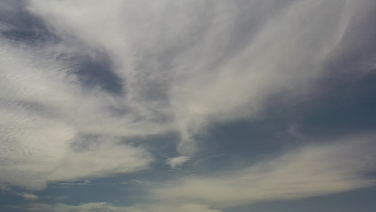 Opening frame of the Los Cabos clip showing broad white and gray cloud bands against a dark blue sky, with no visible people.