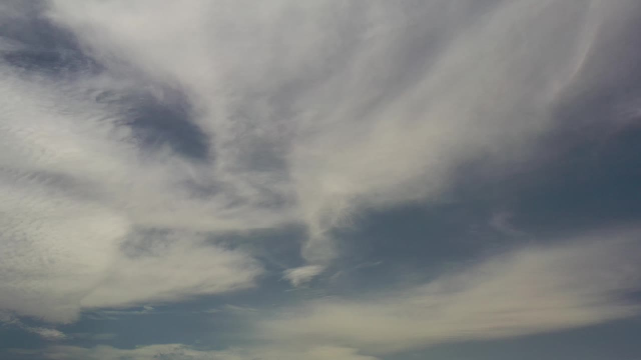 A second upward view in Los Cabos shows layered white cloud cover with a darker blue opening near the lower edge and no visible people.