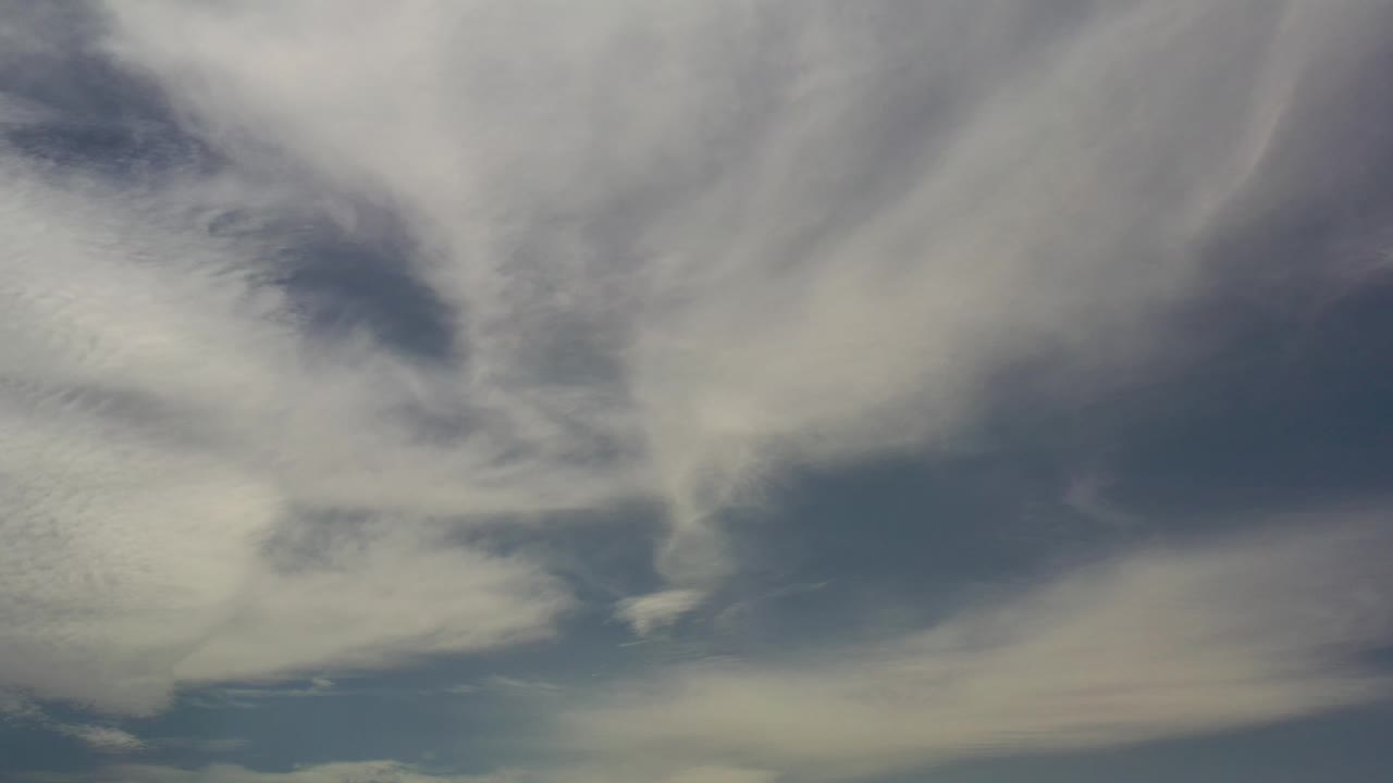 Pale clouds and dark sky in an upward composition.