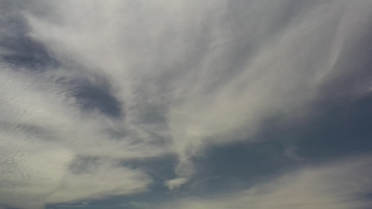 Opening frame of whitish and gray clouds filling the Los Cabos sky, with muted blue gaps and no visible people.