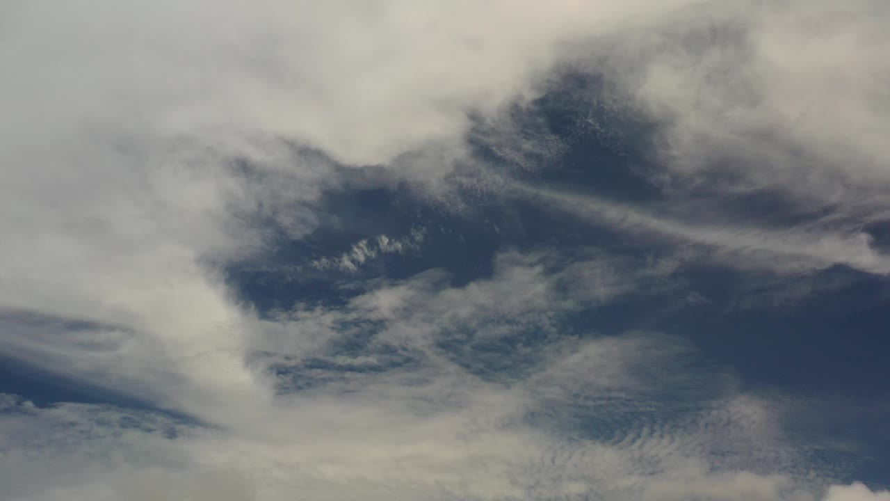White and gray clouds over a deep blue sky.