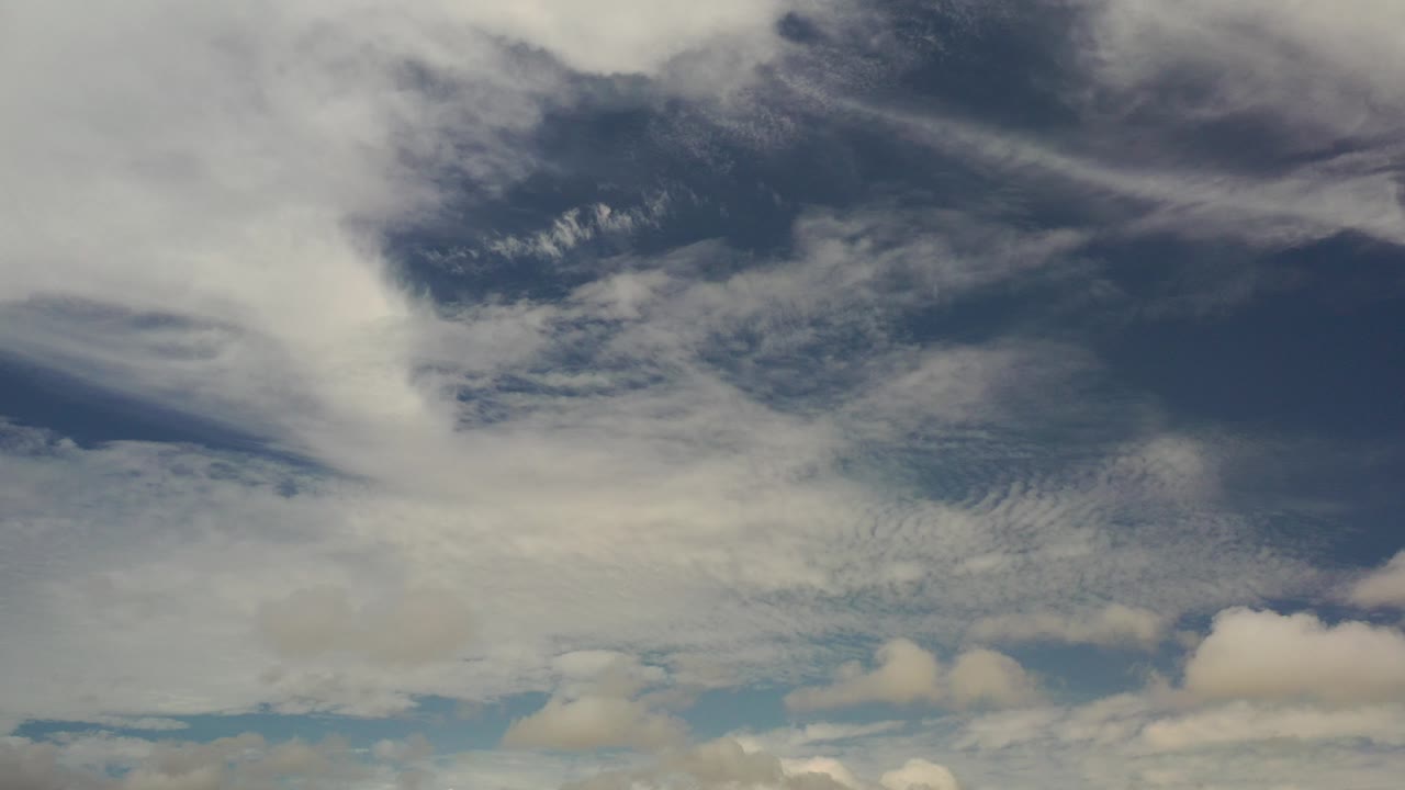 Blue sky with layered white and gray clouds.