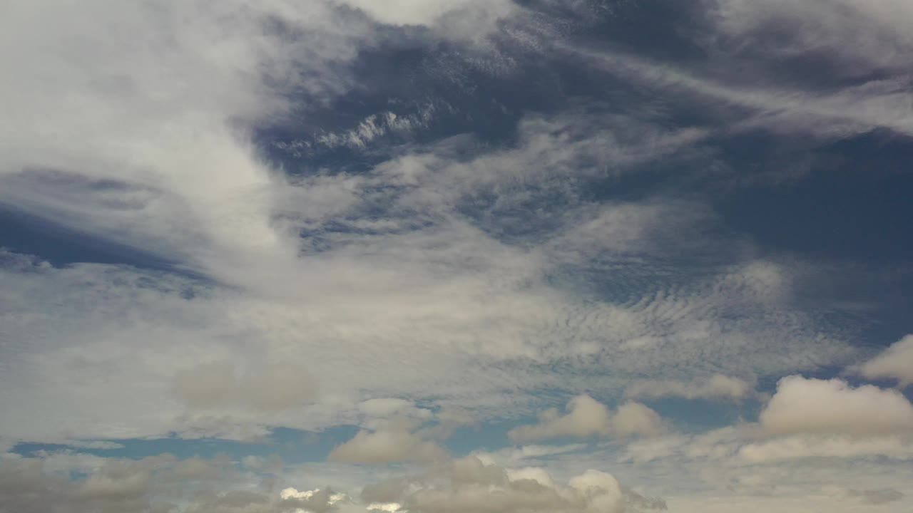 Cloud bands and darker upper sky over small low clouds.