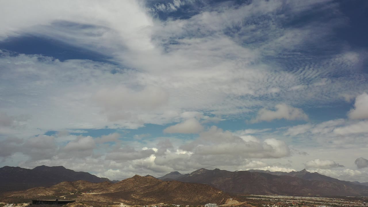 Cloud-filled sky above a low mountain horizon.