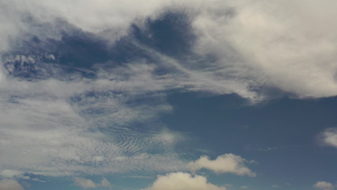 Blue sky with layered white and gray clouds.