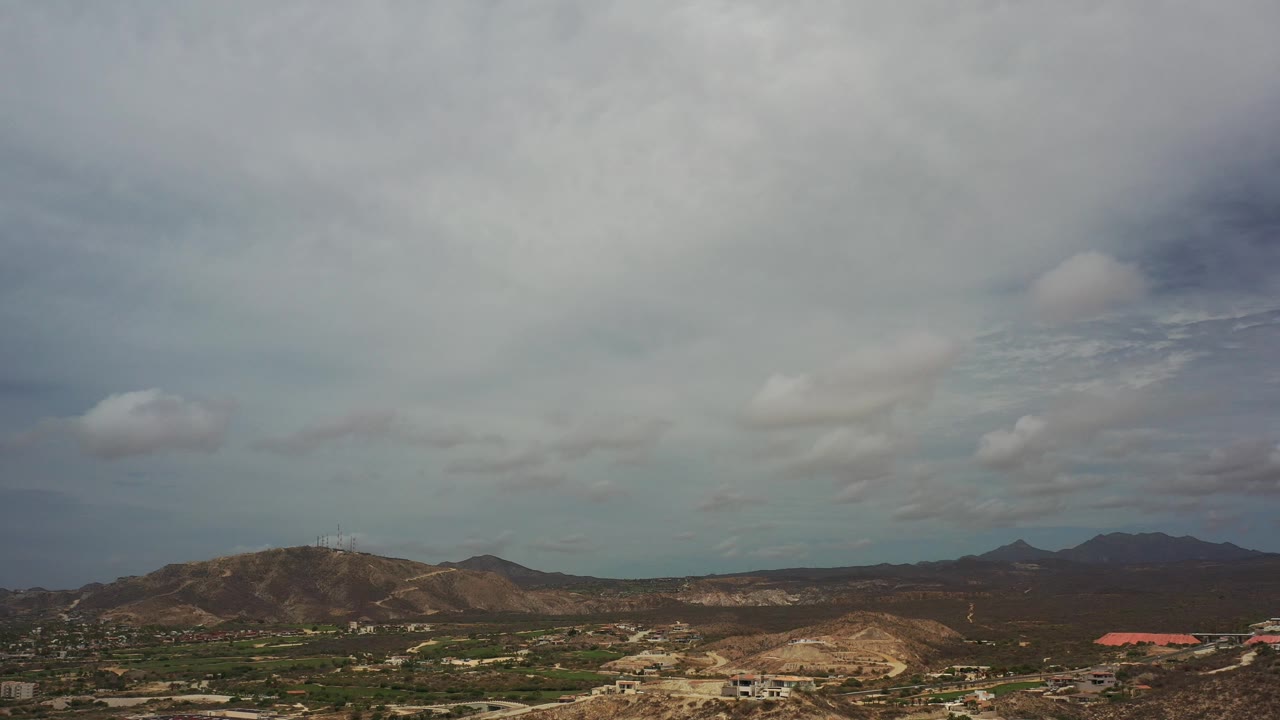 Cloud-heavy sky above a wide arid landscape.