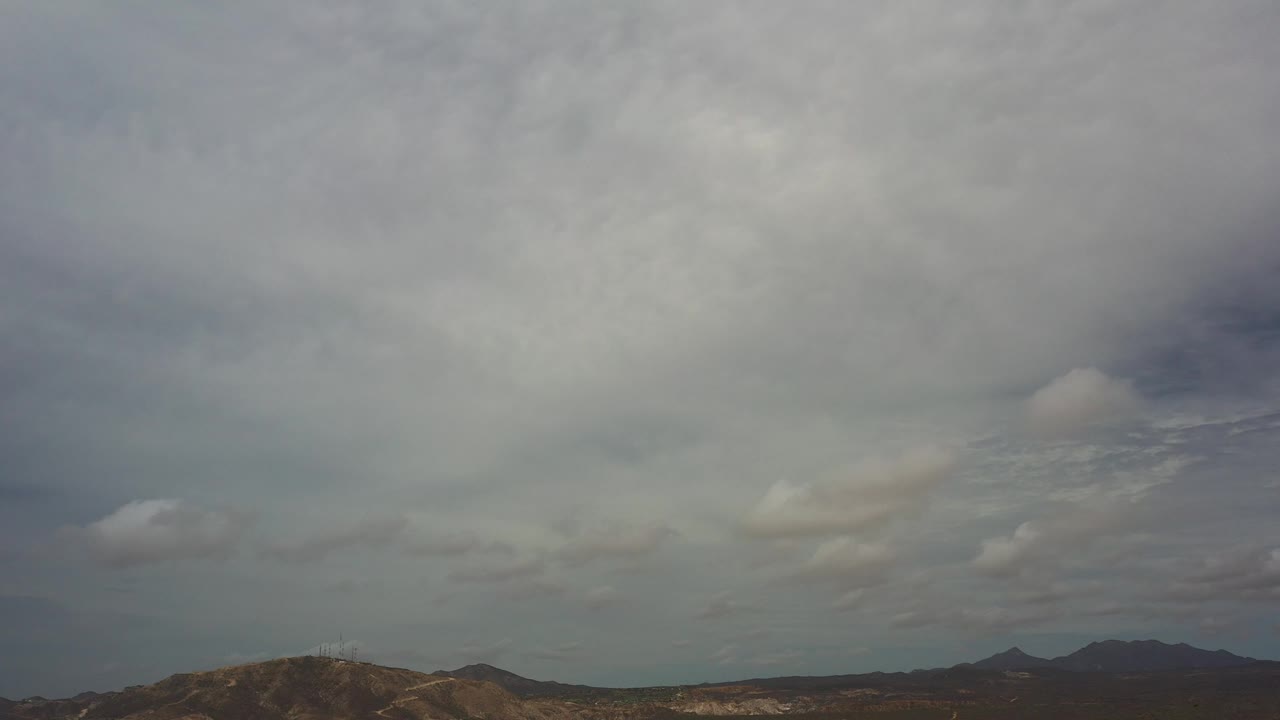 Layered clouds over dry mountain terrain