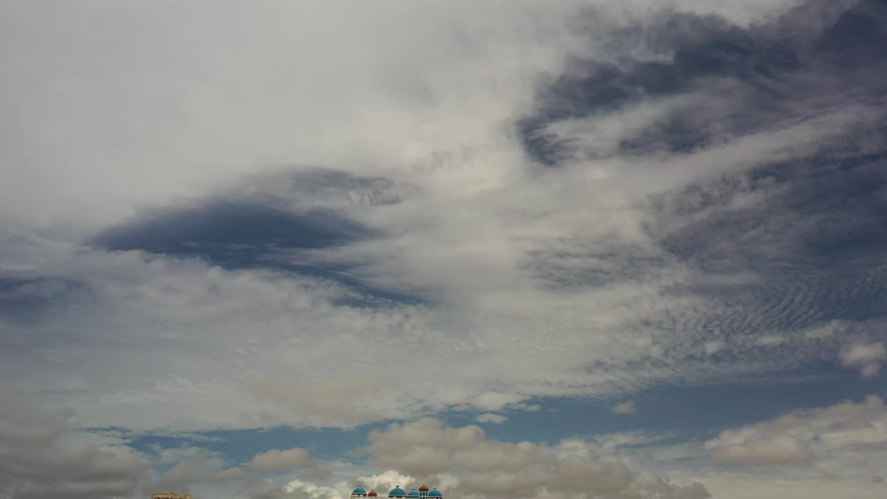 Wide sky view with dense white clouds and a faint horizon strip.