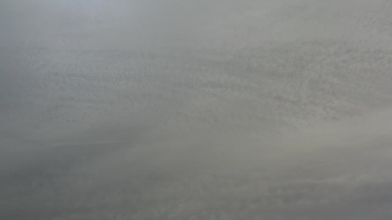 Layered gray cloud cover fills the frame over Los Cabos, Mexico, with soft blue-gray light and no visible people.