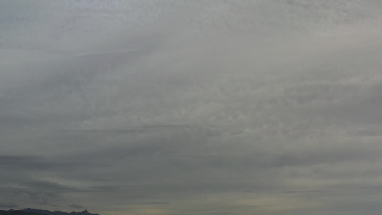At 0:00, gray storm clouds stretch across the sky over a low Los Cabos mountain ridge with no visible people.