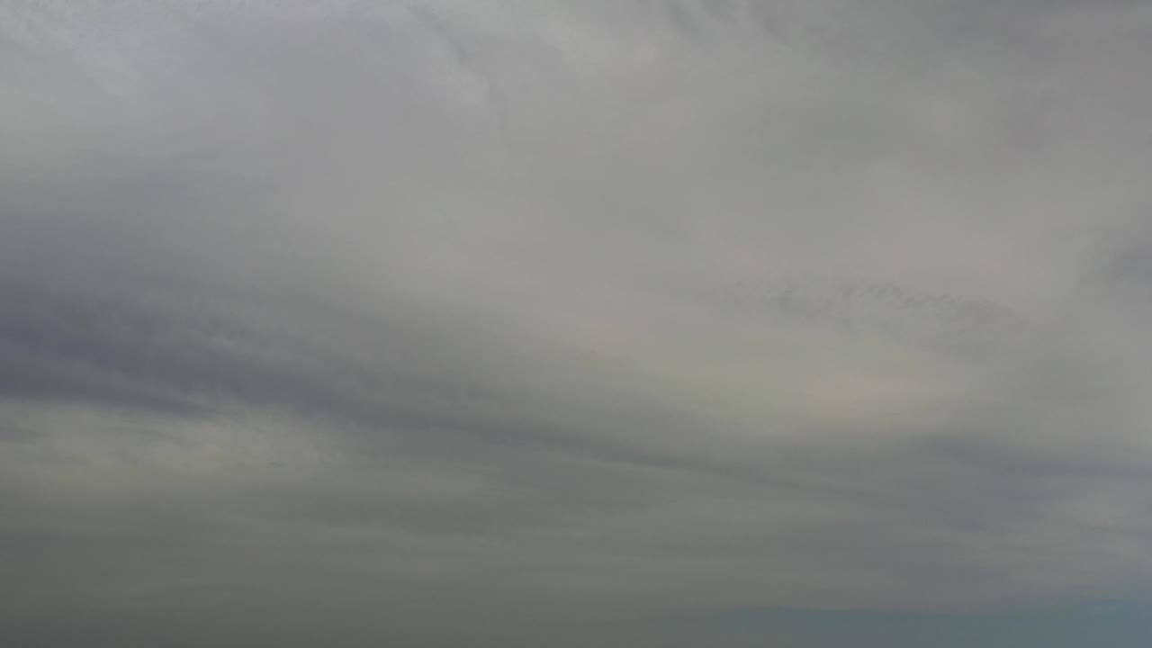 Layered gray clouds cover the Los Cabos sky, with soft darker streaks through the middle and no visible people.