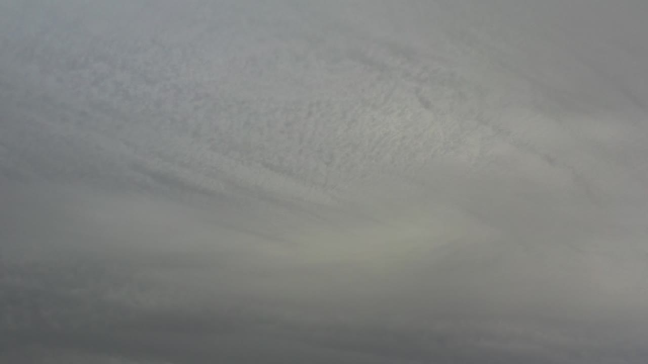 Grey layered cloud cover fills the frame in Los Cabos, Mexico, with darker cloud bands low in the image and no visible people.