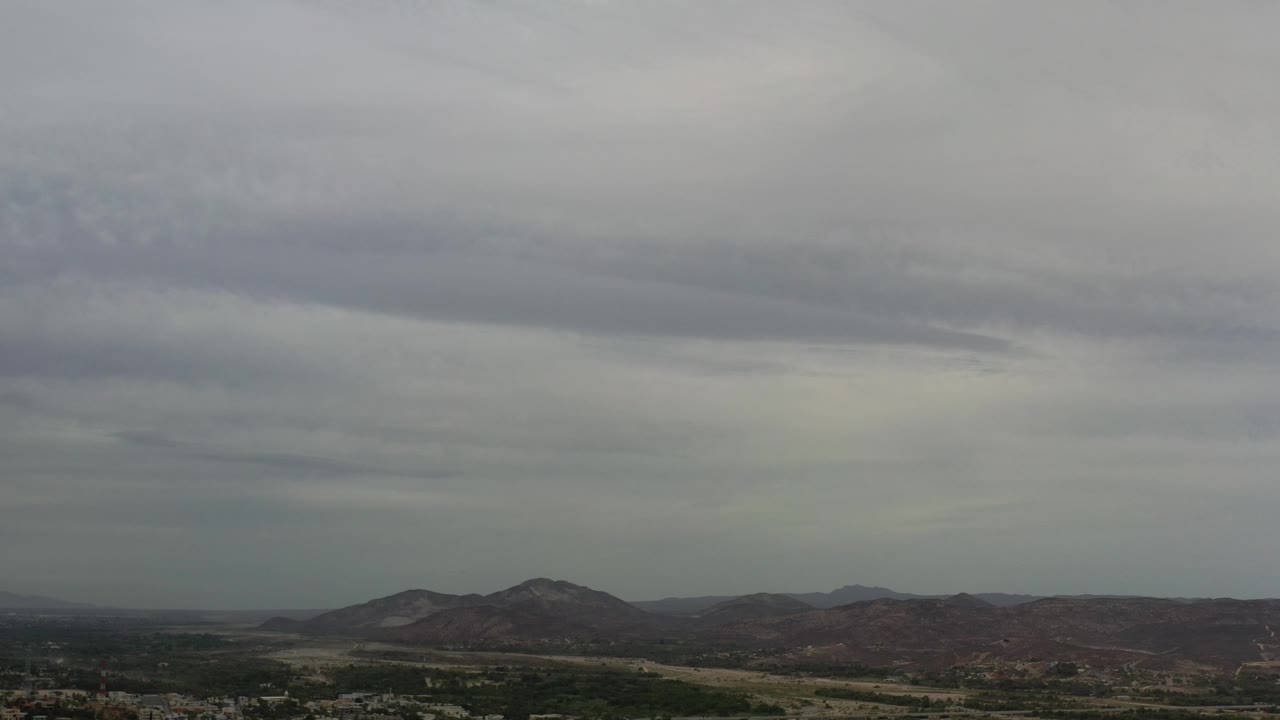Mountains beneath layered gray and white clouds