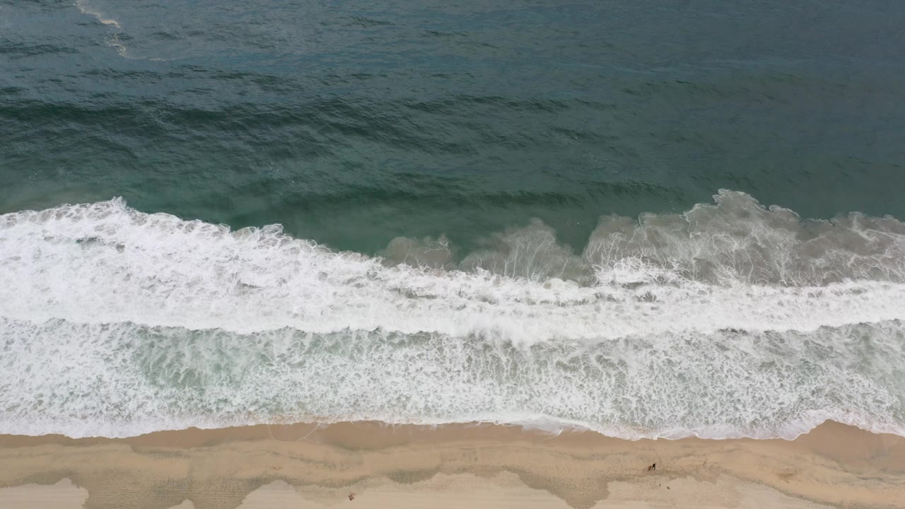 Dark ocean water behind a foamy wave line