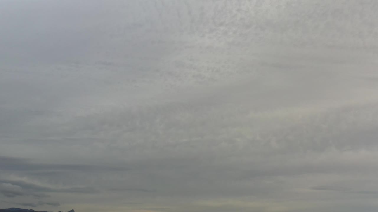 Soft gray clouds above a faint land horizon.