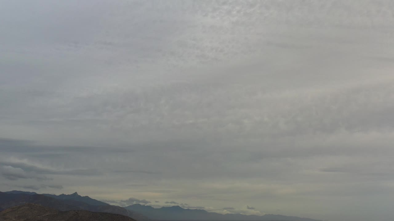 Clouded sky with mountains and pale ridgelines below