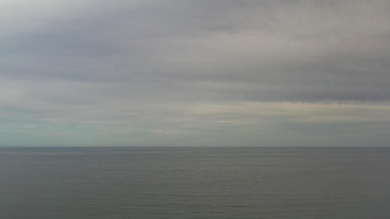 Overcast ocean horizon with gray clouds