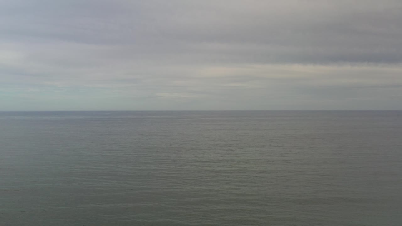 Gray ocean water beneath a low cloudy sky.