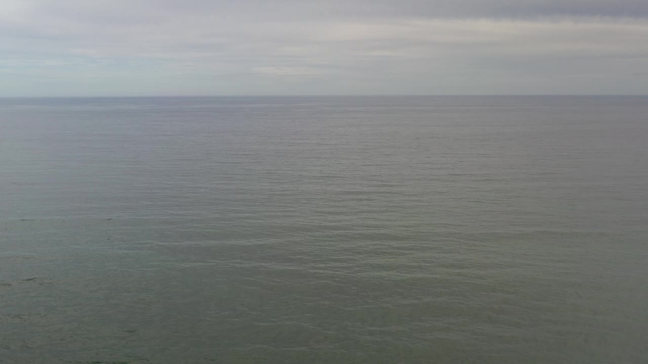 Blue-green sea surface with distant horizon.