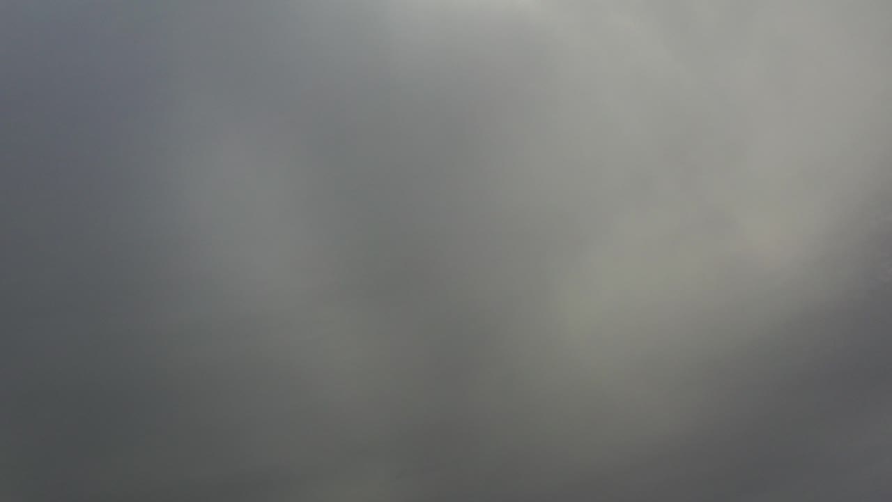 Los Cabos sky filled with soft dark gray cloud cover and pale white patches, no visible people.