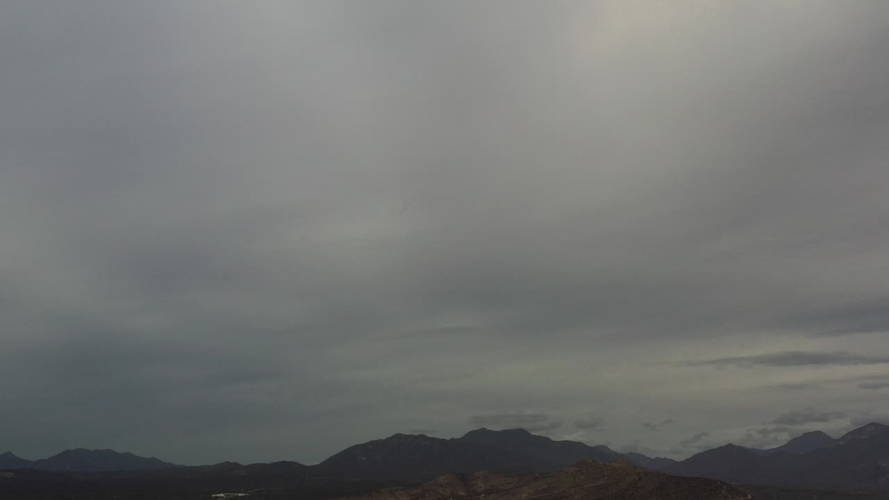 Wide overcast skyline above distant hills and water.