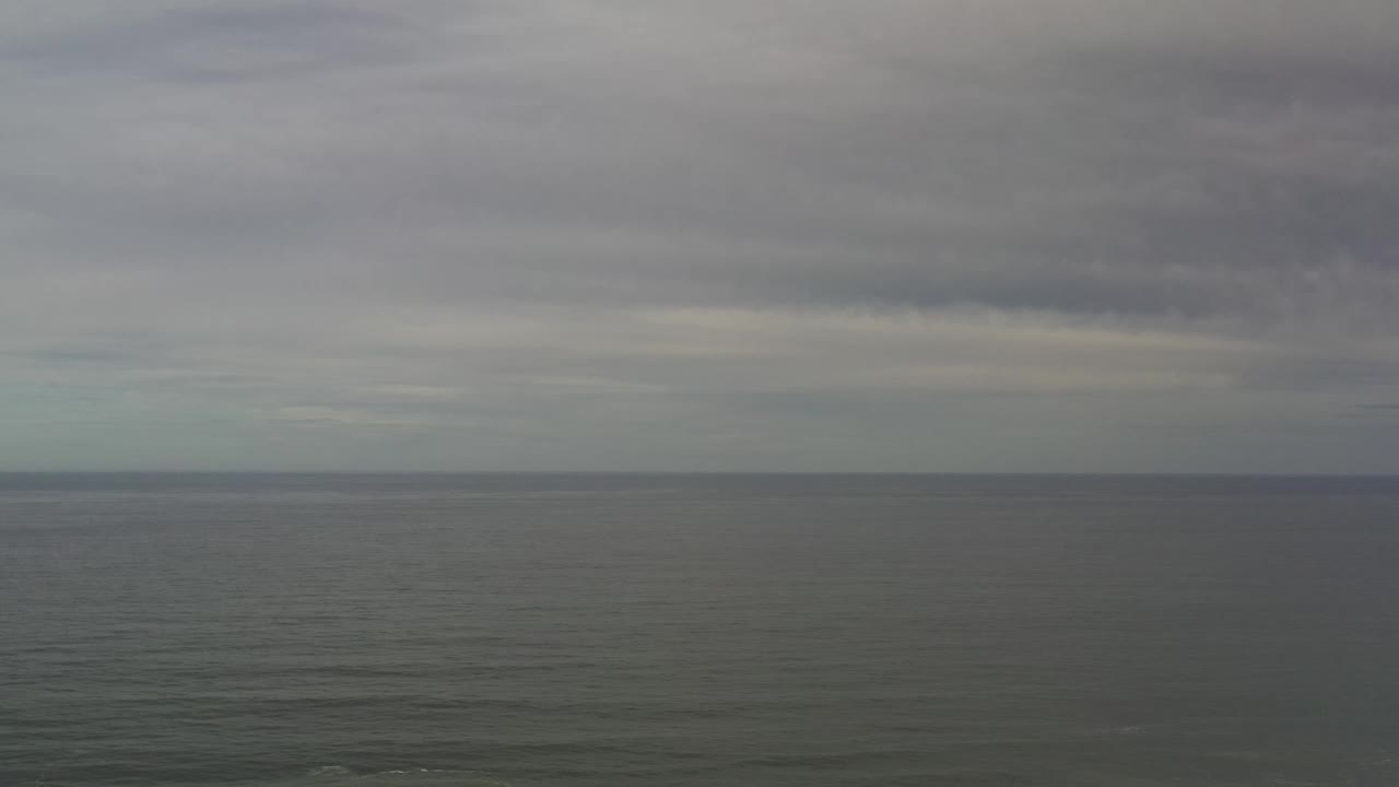 Los Cabos sea and sky view one second in, with the straight horizon dividing textured water from thick gray clouds and no visible people.
