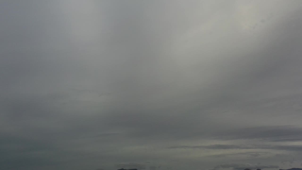 Gray cloud cover above distant mountain ridge