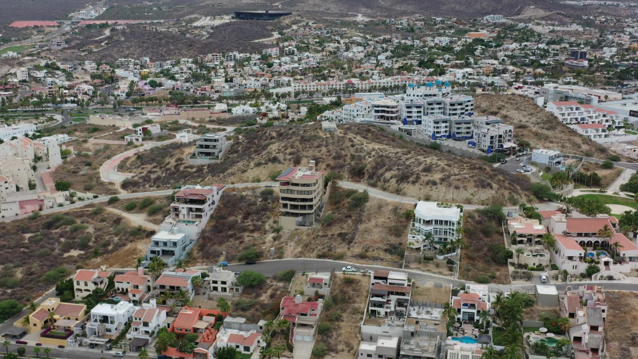 Dry hillside with villas and dense city blocks beyond.