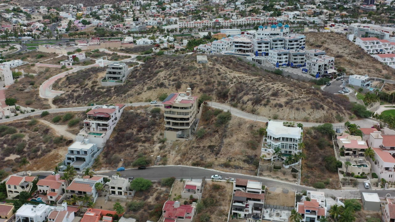 Aerial view of dry hillside homes and curving roads.