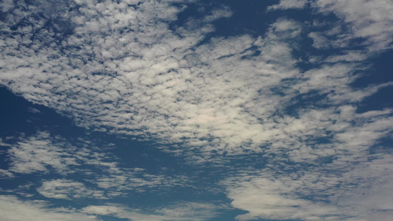 Blue sky with scattered white clouds.