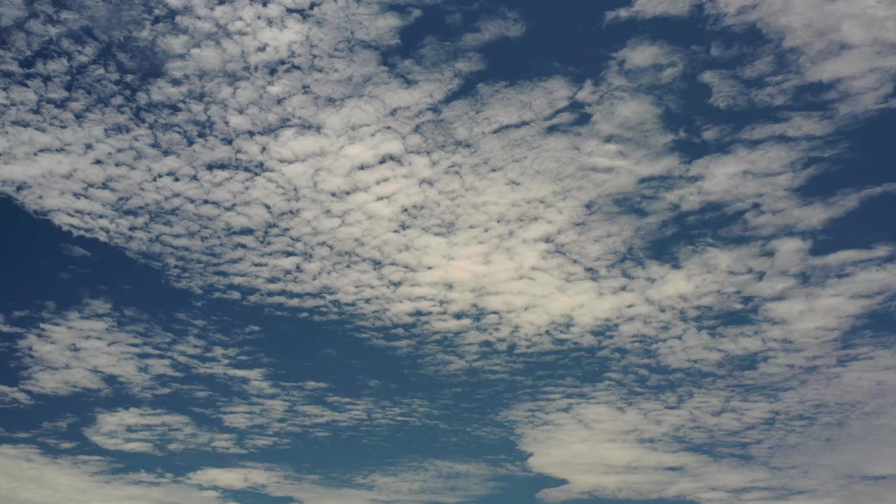 Second frame of the Los Cabos sky showing dense white cloud clusters across the top half and thinner cloud bands below, with no visible people.