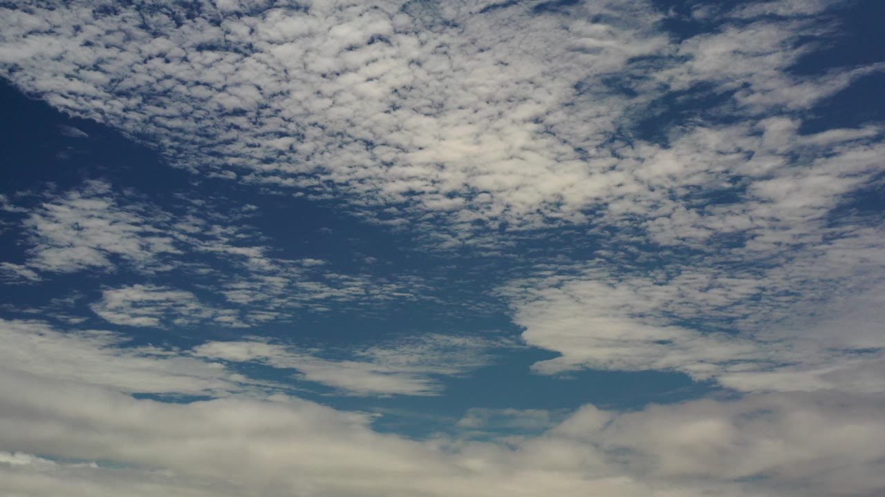 Opening frame of a cloudy blue sky over Los Cabos, Mexico, with a thin horizon at the bottom and no visible people.