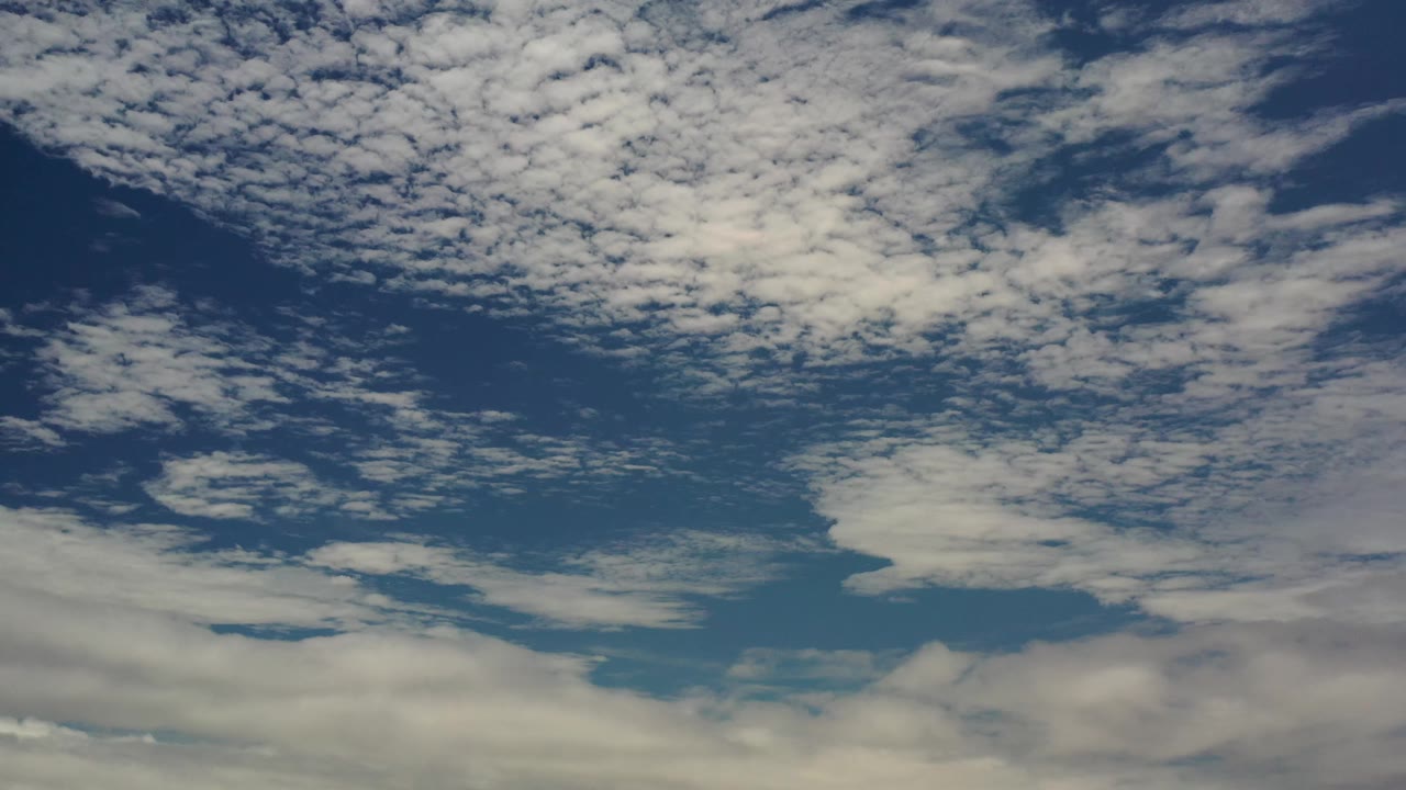 A later moment in the Los Cabos sky view shows patchy white cloud cover across deep blue tones with no visible people.