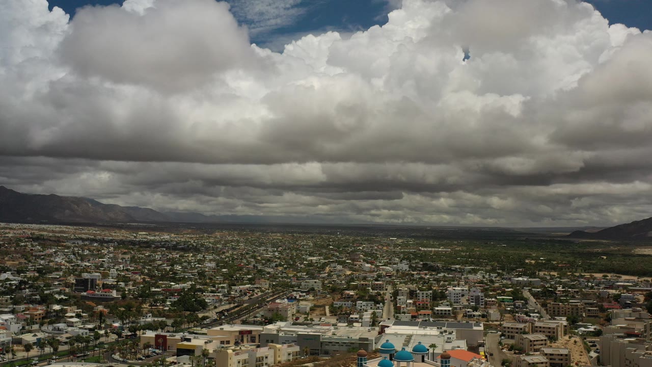 Aerial city panorama with mountains and thick clouds