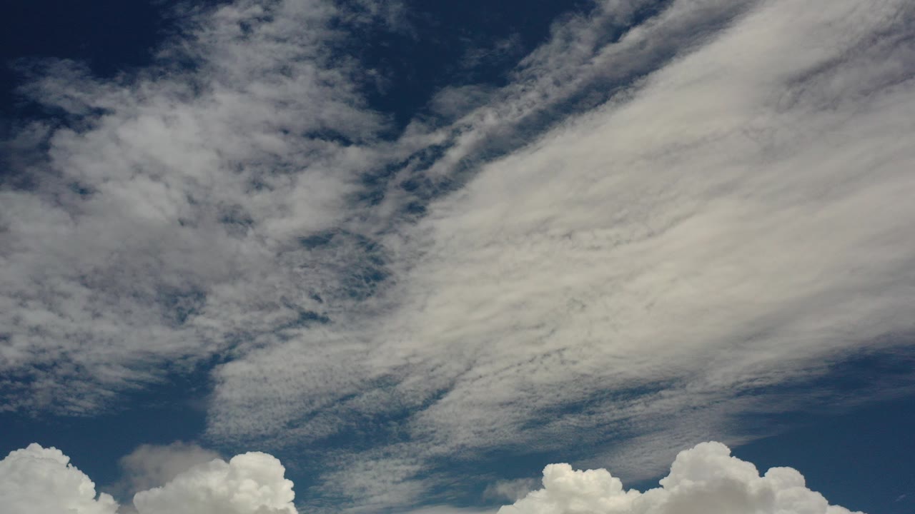 White clouds spread across a dark blue sky.
