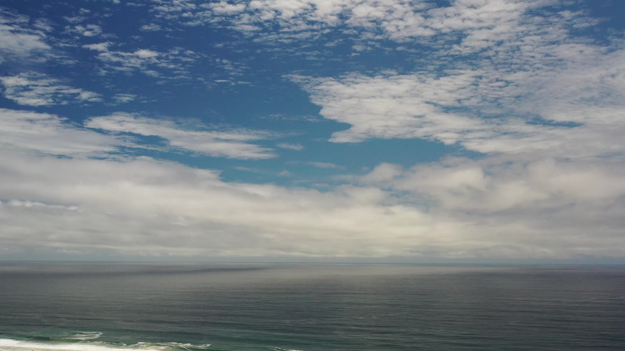 Wide ocean horizon beneath scattered clouds