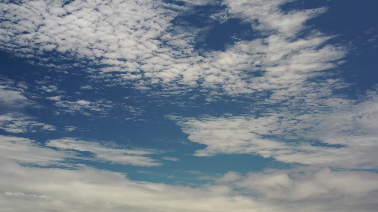 Patchy clouds spread across blue sky