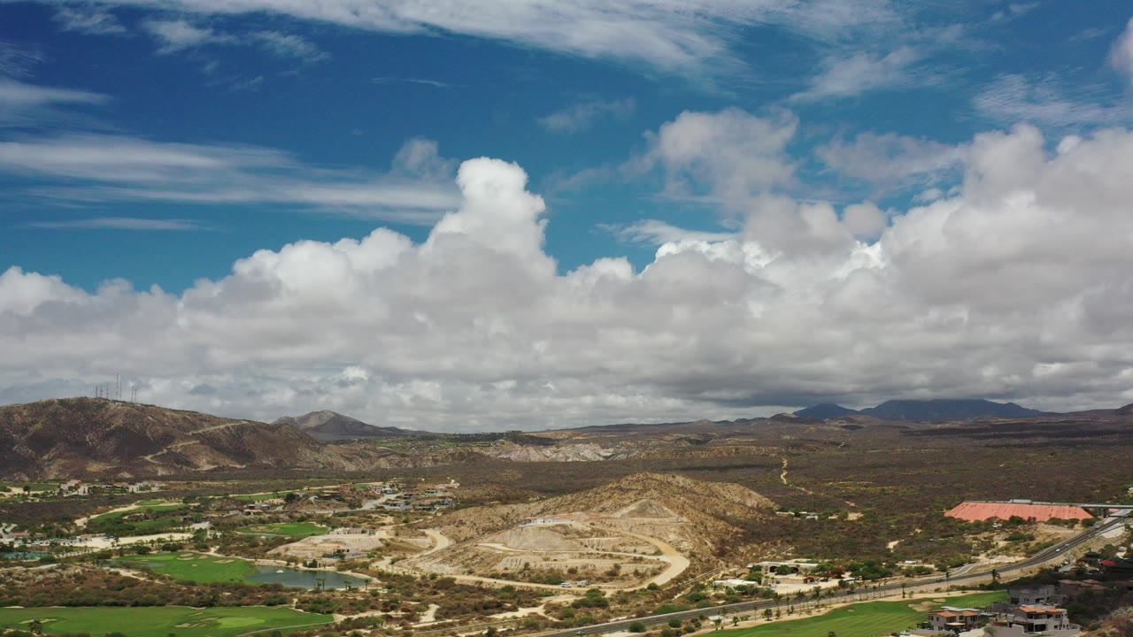 Aerial view of arid hills under large clouds