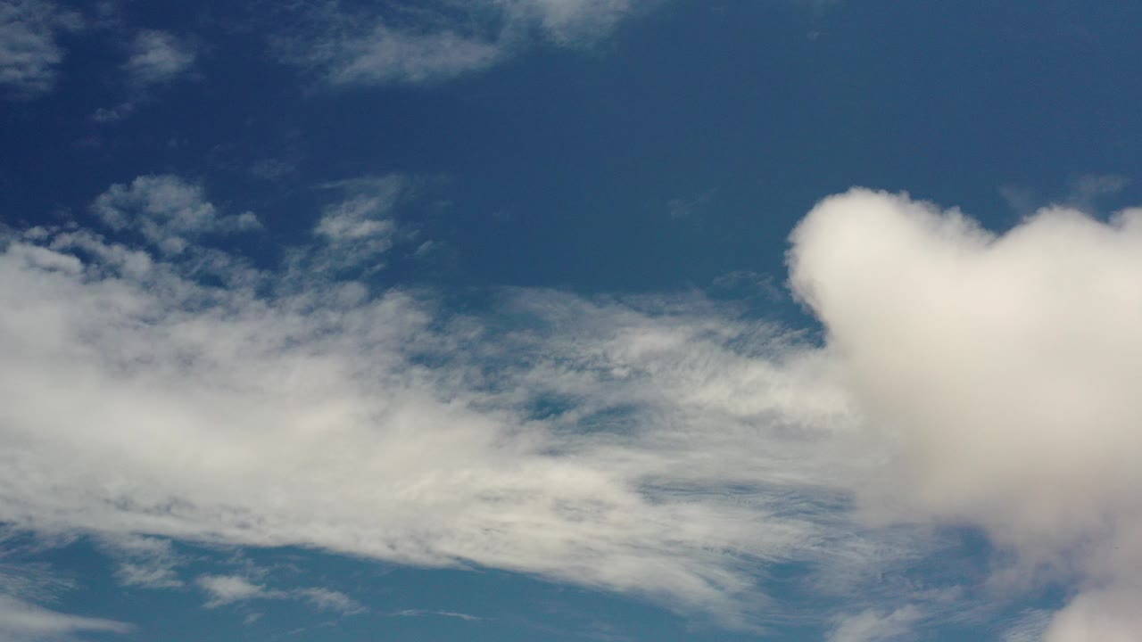At the start of the Los Cabos, Mexico clip, white clouds sit across the lower frame and right edge against a deep blue sky with no visible people.