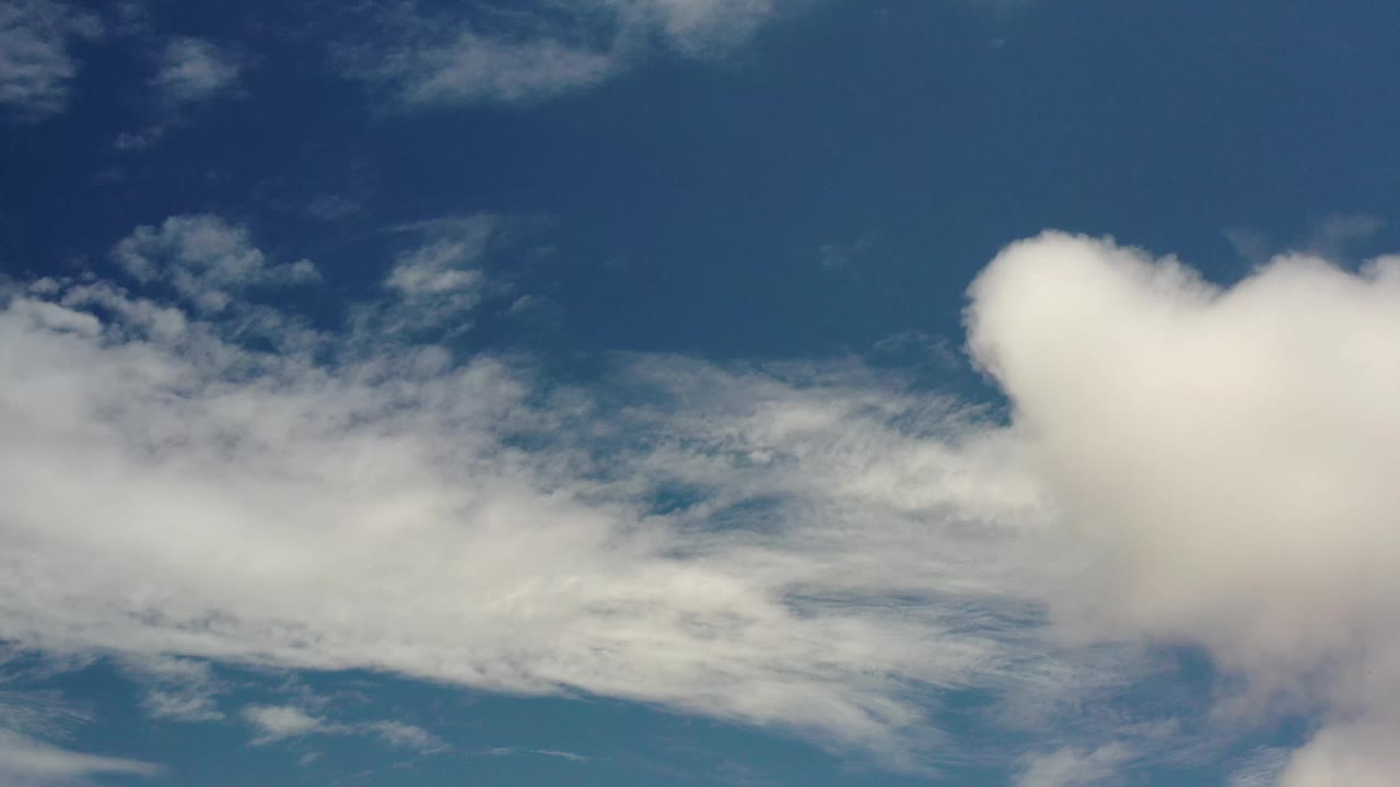 One second into the Los Cabos, Mexico sky shot, a rounded white cloud mass sits near the upper right while thinner cloud bands cross the middle, with no visible people.